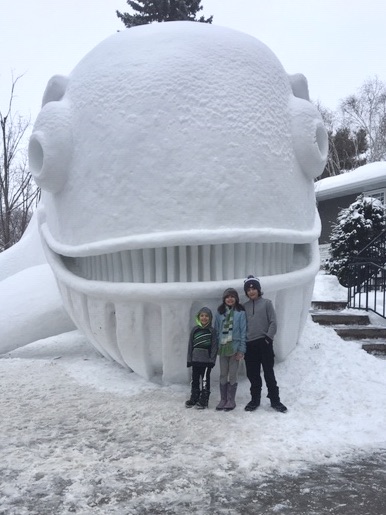 Big kids and a snow sculpture of a whale